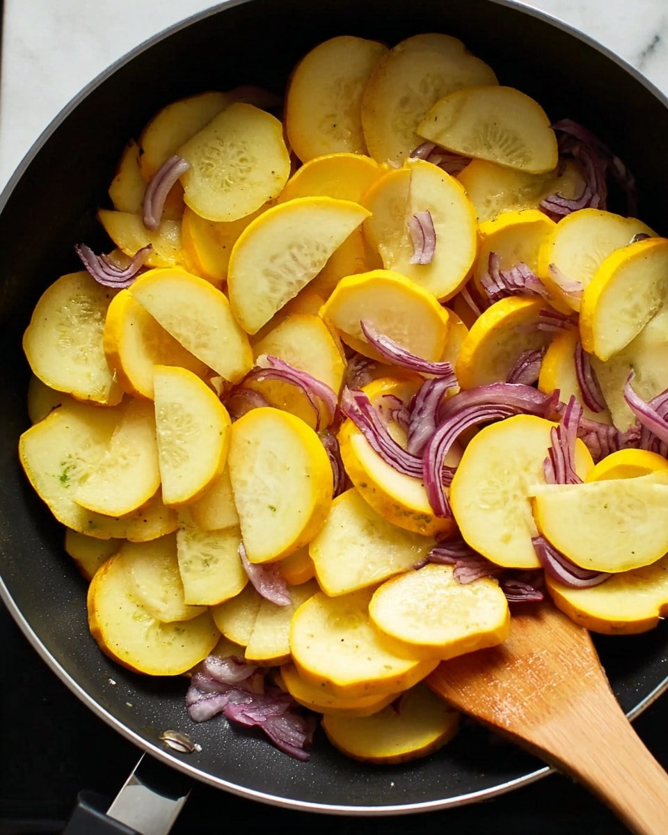 The image shows a black cooking pan filled with many slices of yellow summer squash mixed with pieces of red onion. The squash slices are curved with pale yellow flesh and bright yellow skin, arranged in layers covering most of the pan's surface. The red onion pieces are scattered under and among the squash, showing deep purple color. A wooden spatula is partially visible in the bottom right corner, stirring the vegetables. The pan sits on a white marbled surface. photo taken with an iphone --ar 4:5 --v 7