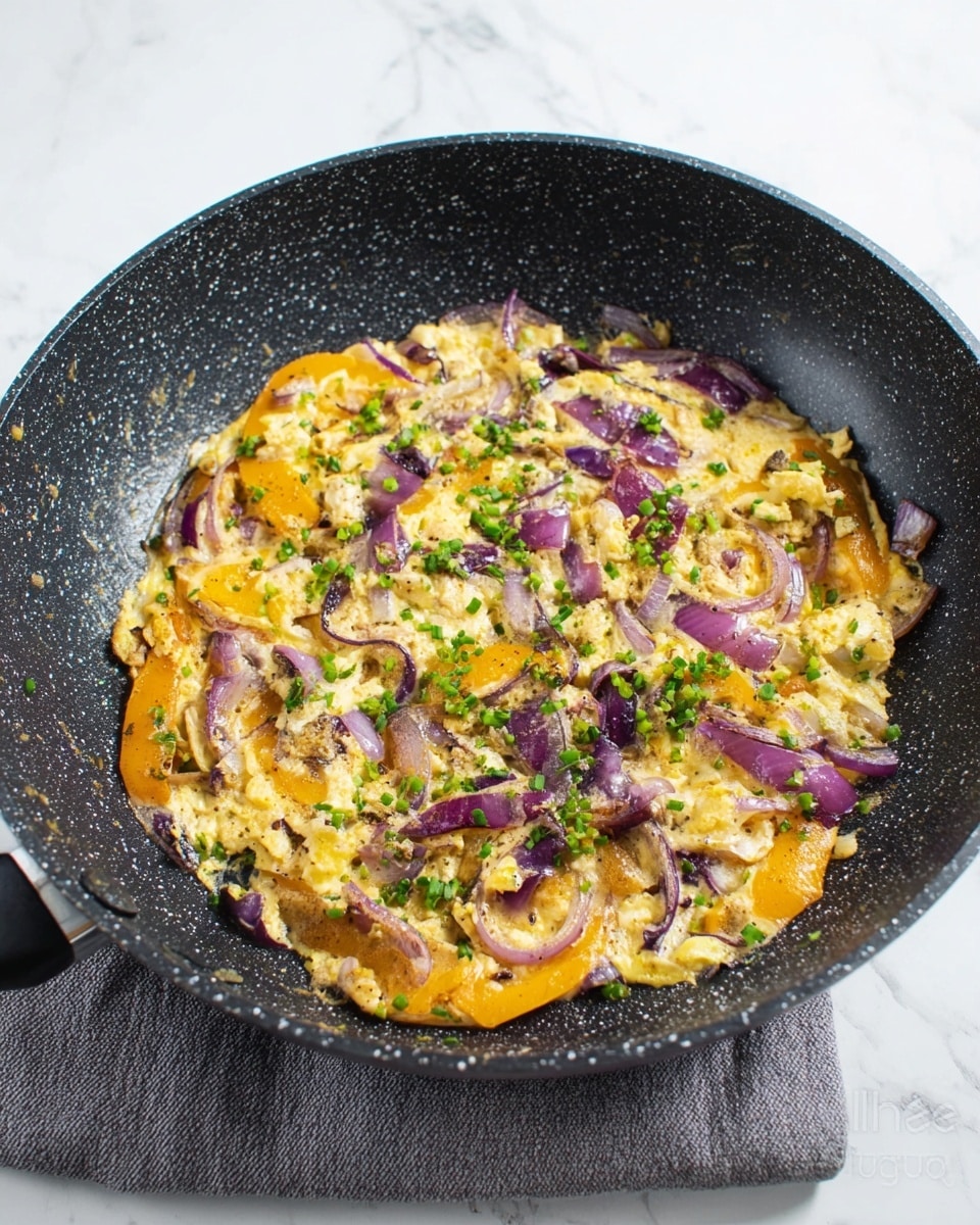 A black speckled pan sits on a white marbled surface with cooked food inside. The food has three main parts: light yellow scrambled eggs with a soft and slightly chunky texture, orange-yellow bell pepper slices with a tender look, and cooked purple onion slices with a slightly translucent shine. These ingredients are mixed together evenly. Small green parsley pieces are sprinkled on top, adding a fresh touch of color. There is a light brown wooden spatula resting on the right side of the pan, partially under the food. Photo taken with an iphone --ar 4:5 --v 7