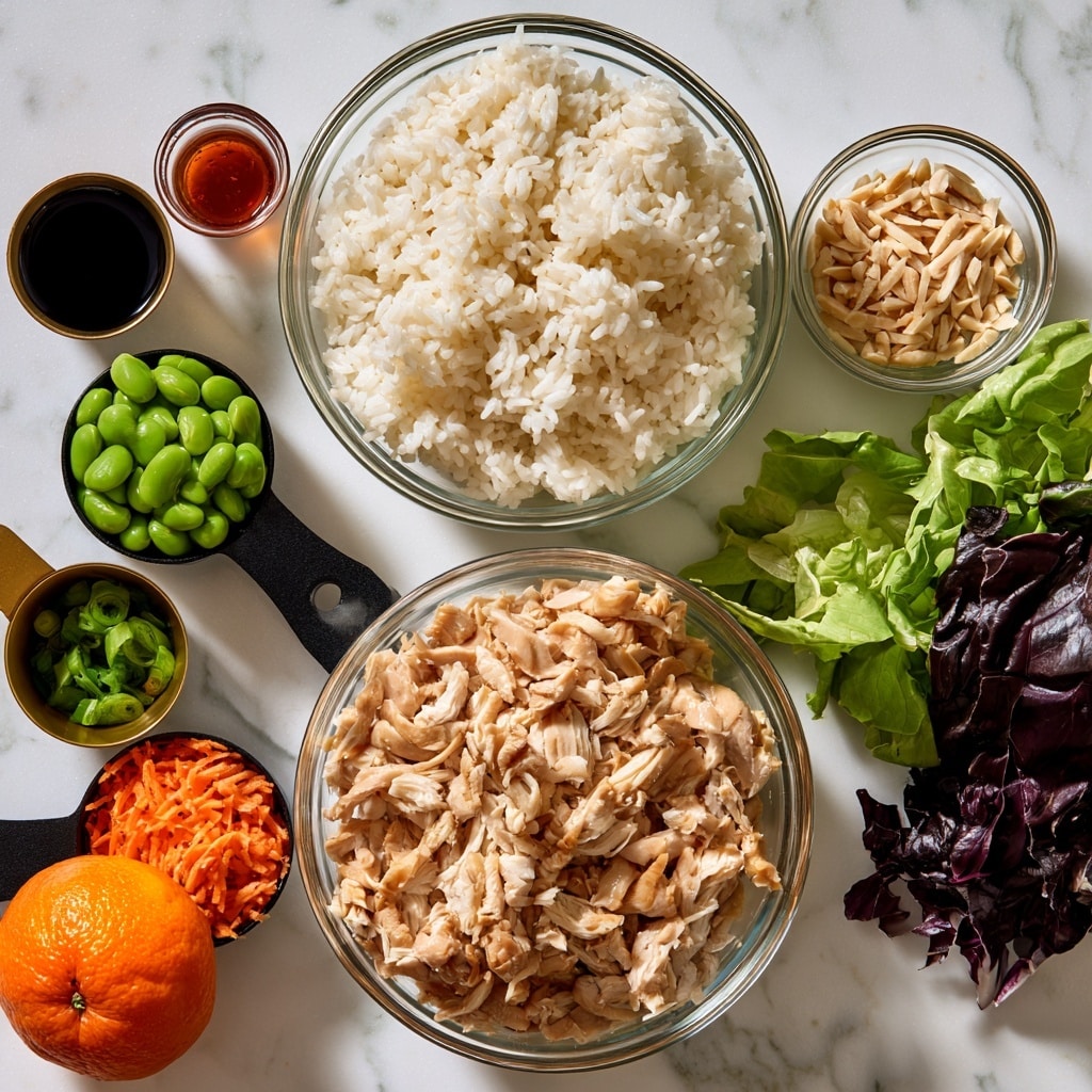 The image shows multiple clear glass bowls and measuring cups arranged on a white marbled surface, each holding a different ingredient. In the center is a large bowl with light brown shredded chicken. Above it is a medium bowl filled with fluffy white cooked rice. To the right is a small bowl with slivered almonds next to fresh green and dark purple cabbage leaves. On the left side, a black measuring cup holds bright green edamame, and a smaller golden cup contains chopped green onions. Next to them is a black measuring cup with orange shredded carrot and a whole mandarin orange beside it. Above these is a small cup with dark soy sauce and a tiny cup with reddish brown sesame oil. All ingredients are spread out clearly, showing a variety of colors and textures. Photo taken with an iphone --ar 4:5 --v 7