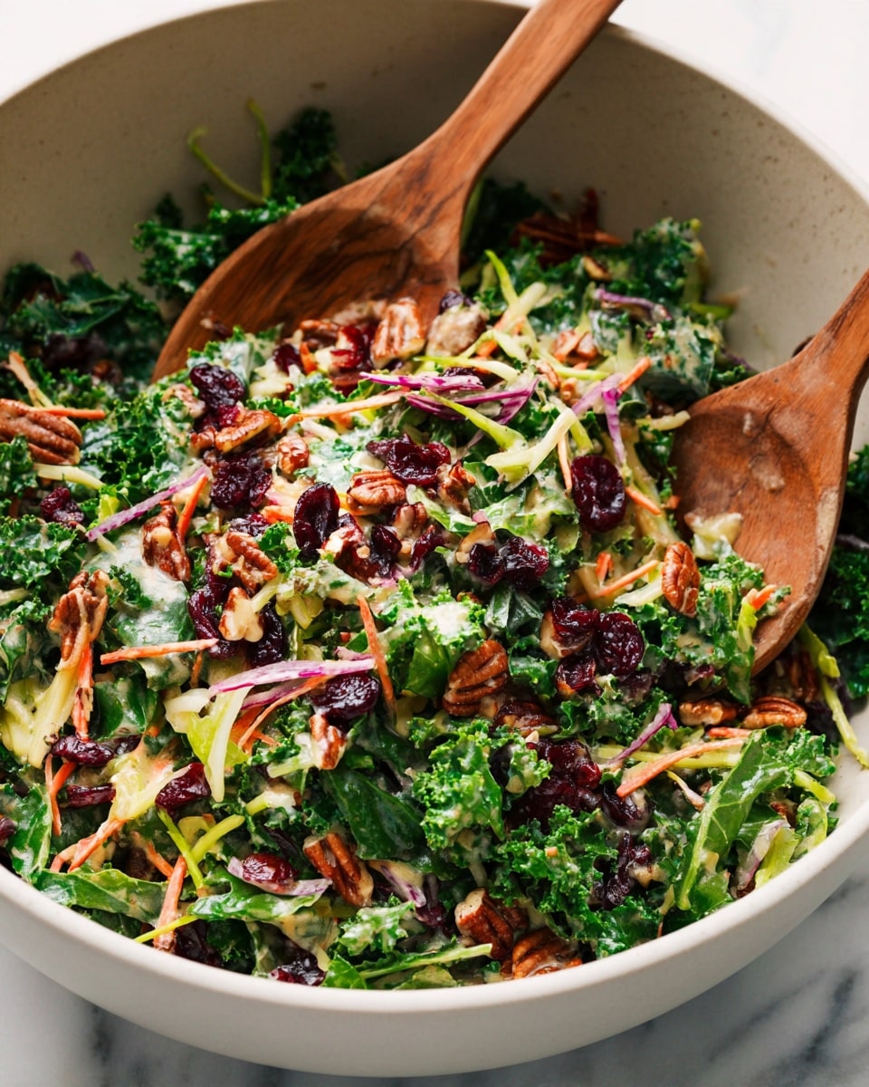 A close-up view of a fresh salad in a large white bowl on a white marbled surface, showing a mix of kale leaves deep green in color as the main base layer, with thin light green broccoli stems and orange shredded carrots scattered throughout. On top of the greens, there are dark red dried cranberries, golden brown candied pecans, and bits of purple cabbage adding color contrast. A creamy dressing with a light beige tone is lightly spread across the salad, giving it a shiny texture. Two wooden spoons, natural brown with grain patterns, are partially immersed in the salad, ready to mix. photo taken with an iphone --ar 4:5 --v 7