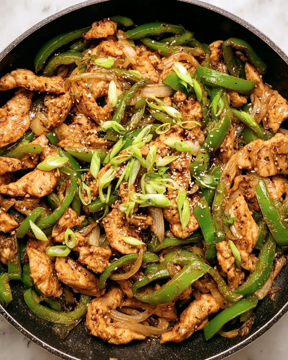 The image shows a pan filled with cooked stir-fried chicken strips mixed with thin green bell pepper slices and light brown onion pieces. The chicken is golden brown with some darker seared edges, while the green peppers add a fresh bright contrast throughout the dish. On top, there are scattered thinly sliced green onion pieces adding a fresh green color accent. The dish is sprinkled with sesame seeds and some black pepper for texture and color. The pan sits on a white marbled surface. photo taken with an iphone --ar 4:5 --v 7